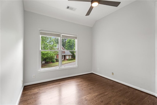 empty room with wood finished floors, a ceiling fan, visible vents, and vaulted ceiling