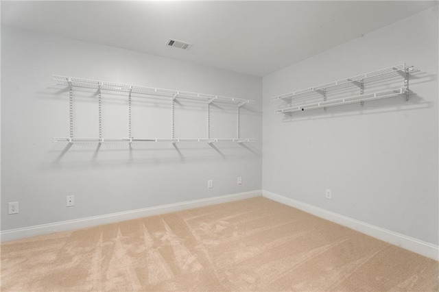 walk in closet with visible vents and carpet