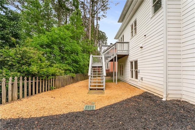 view of yard with fence, stairway, and a deck