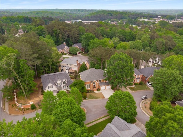 birds eye view of property featuring a wooded view and a residential view