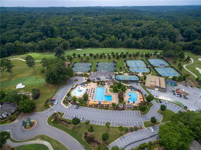 drone / aerial view with golf course view and a forest view