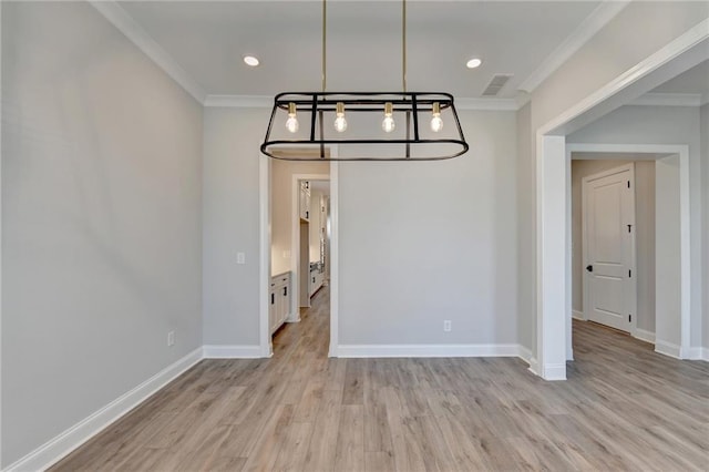 unfurnished dining area with a chandelier, light hardwood / wood-style floors, and crown molding