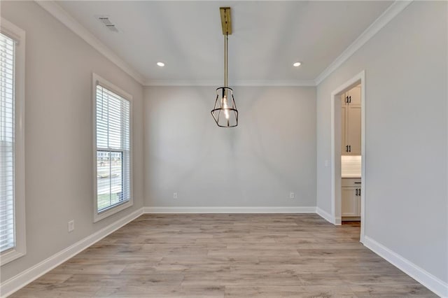 unfurnished dining area featuring crown molding and light hardwood / wood-style flooring