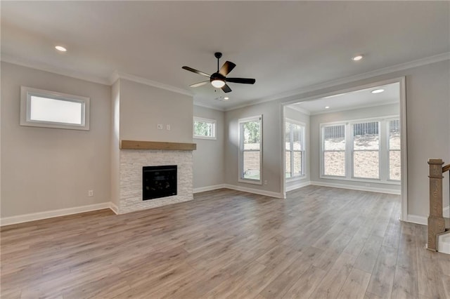 unfurnished living room featuring ceiling fan, a stone fireplace, crown molding, and light hardwood / wood-style floors