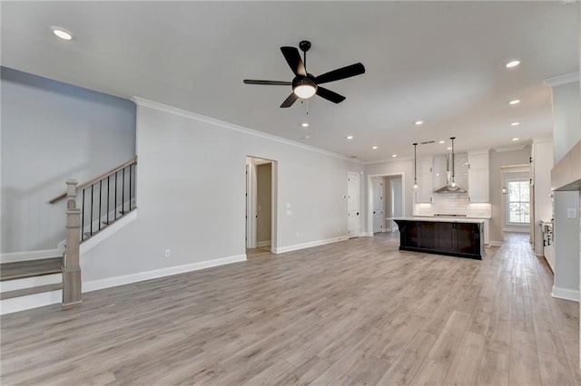 unfurnished living room with ornamental molding, light wood-type flooring, and ceiling fan