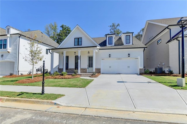 view of front of house with a garage, a front yard, central AC unit, and covered porch