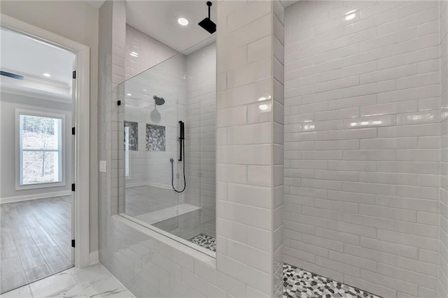 bathroom with wood-type flooring and tiled shower