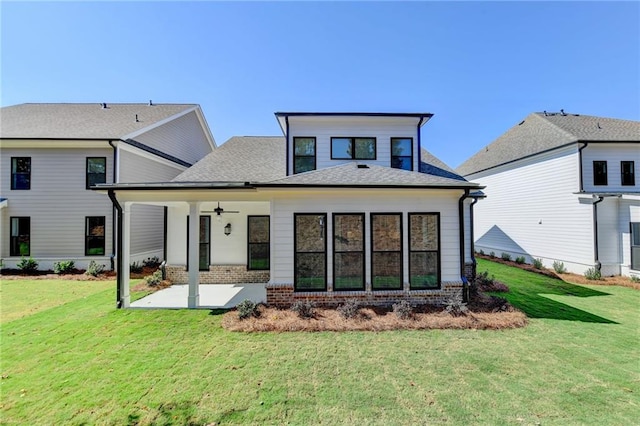 rear view of property with ceiling fan, a lawn, and a patio area