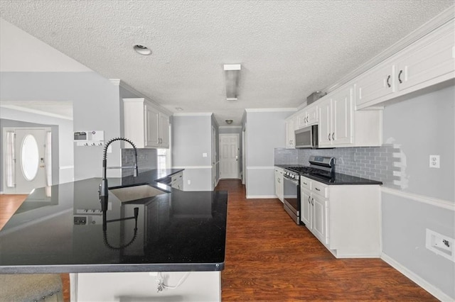 93 Pebble Creek Dr, Newnan, GA 30265 - kitchen featuring stainless steel appliances, dark countertops, a peninsula, a textured ceiling, and dark wood-style flooring
