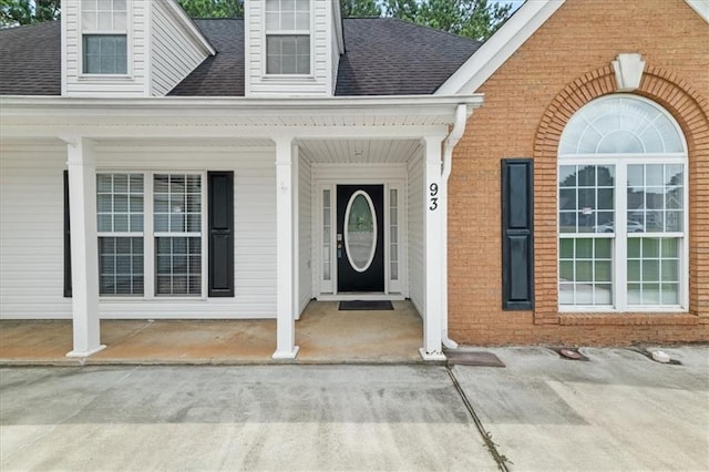 93 Pebble Creek Dr, Newnan, GA 30265 - view of exterior entry featuring roof with shingles, brick siding, and a porch