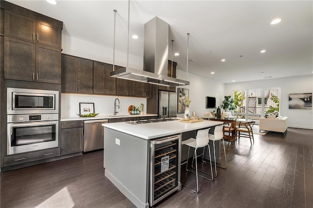 kitchen with sink, wine cooler, a kitchen island, island range hood, and stainless steel appliances