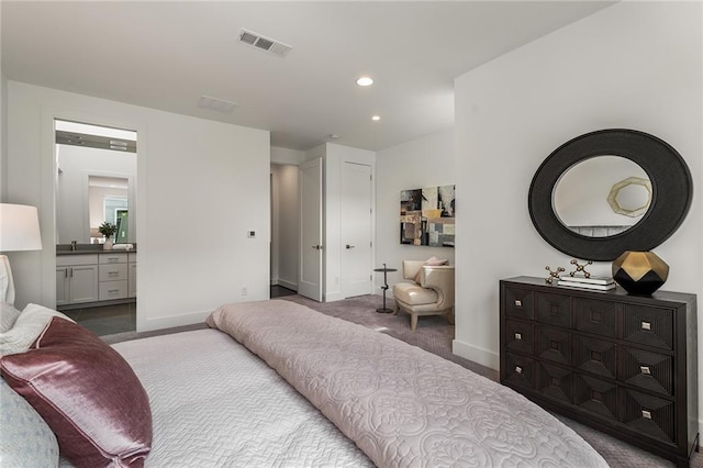 carpeted bedroom featuring ensuite bath