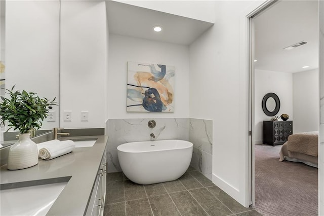 bathroom featuring a tub, tile patterned flooring, and vanity