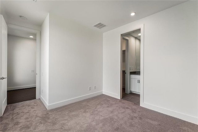 unfurnished bedroom with connected bathroom and carpet