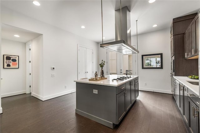 kitchen featuring pendant lighting, stainless steel gas stovetop, ventilation hood, dark hardwood / wood-style floors, and a kitchen island