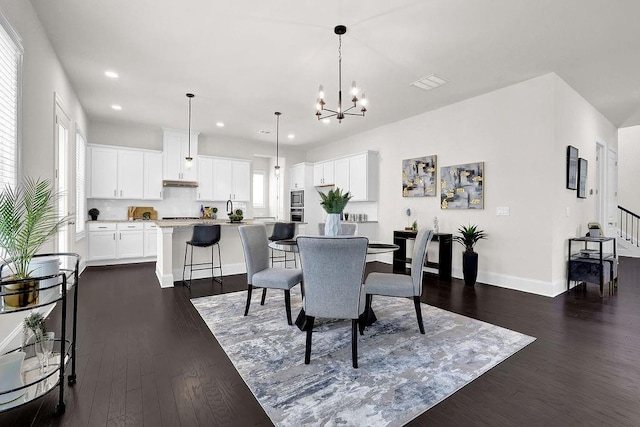 dining area featuring an inviting chandelier, dark hardwood / wood-style floors, and plenty of natural light