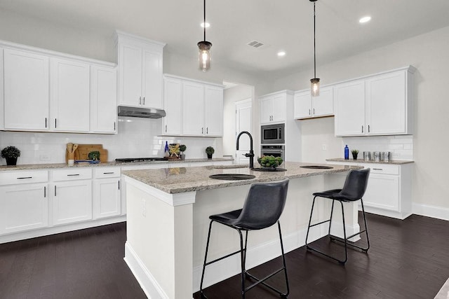 kitchen featuring pendant lighting, sink, white cabinetry, a center island with sink, and stainless steel appliances