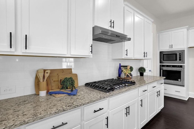 kitchen featuring backsplash, white cabinets, light stone countertops, and appliances with stainless steel finishes