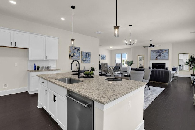 kitchen featuring sink, dishwasher, a kitchen island with sink, and white cabinets