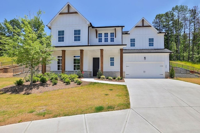 view of front of house featuring a porch, a garage, and a front lawn