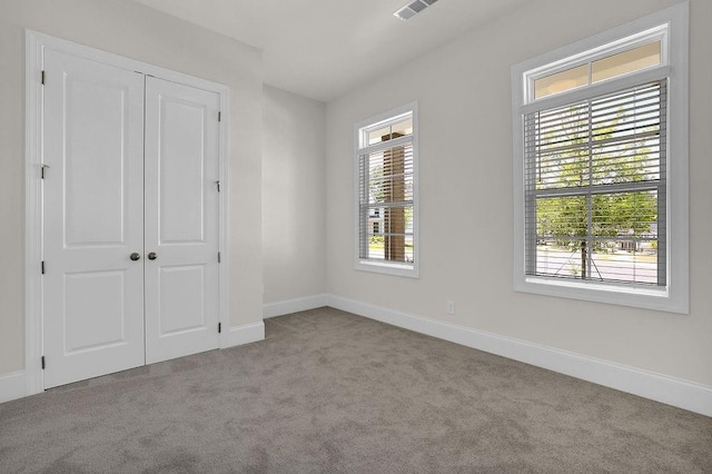 unfurnished bedroom featuring a closet and light carpet