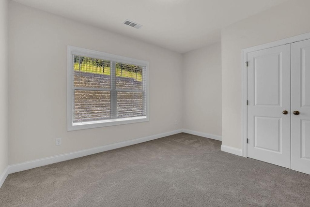 unfurnished bedroom with light carpet and a closet