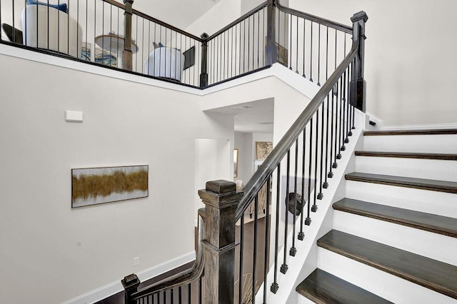 stairway with a high ceiling and hardwood / wood-style floors