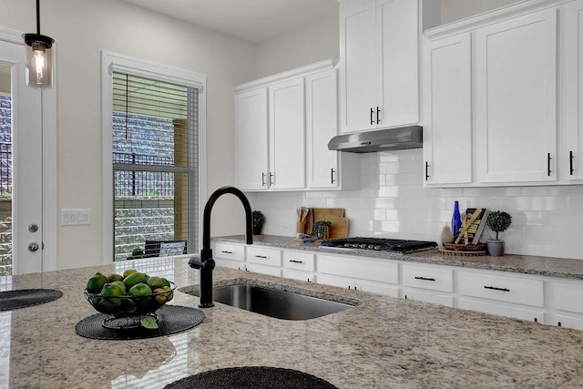 kitchen featuring sink, white cabinets, light stone countertops, and stainless steel gas cooktop