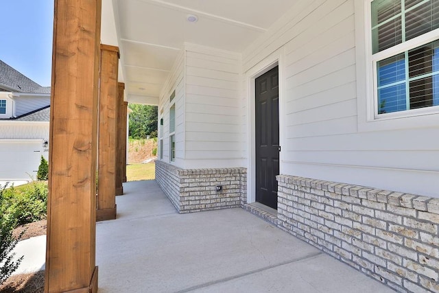 view of patio / terrace with covered porch and a garage