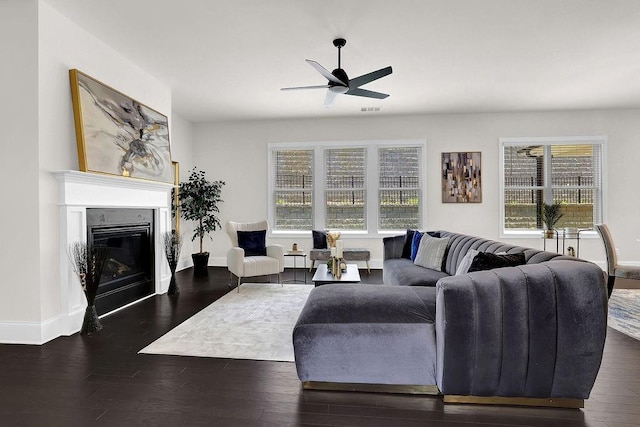 living room with ceiling fan and dark hardwood / wood-style flooring