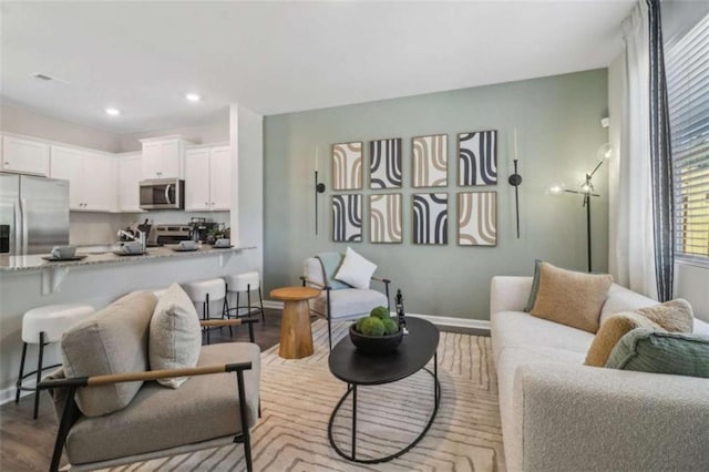 living area featuring recessed lighting, baseboards, and wood finished floors