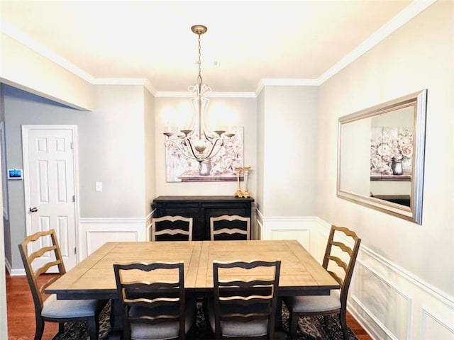 dining space with dark hardwood / wood-style flooring, an inviting chandelier, and ornamental molding