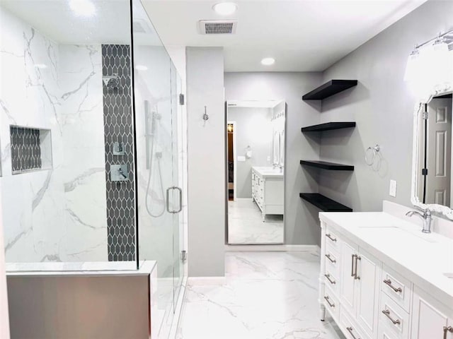 bathroom featuring a shower with door and vanity