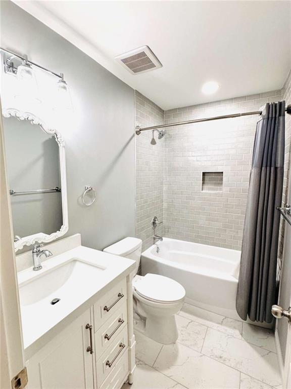 full bathroom with toilet, vanity, and shower / bathtub combination with curtain