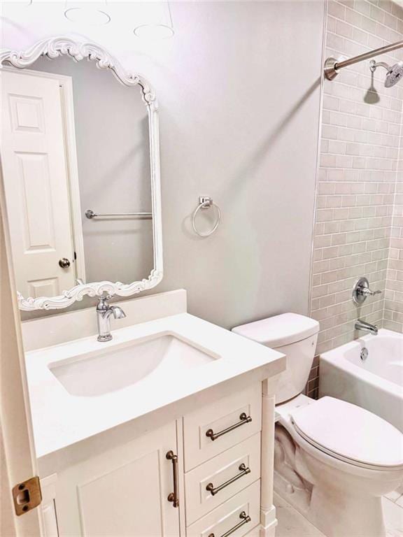 full bathroom featuring toilet, vanity, and tiled shower / bath