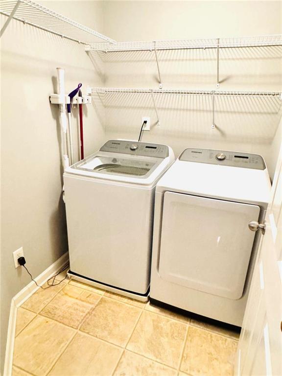 washroom with light tile patterned flooring and washer and clothes dryer