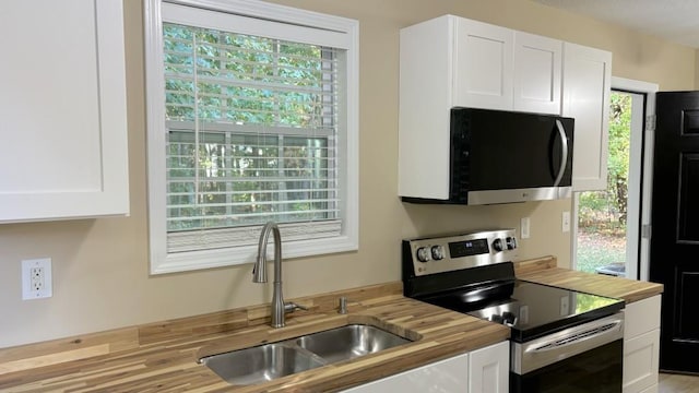 kitchen with white cabinets, a wealth of natural light, sink, and appliances with stainless steel finishes