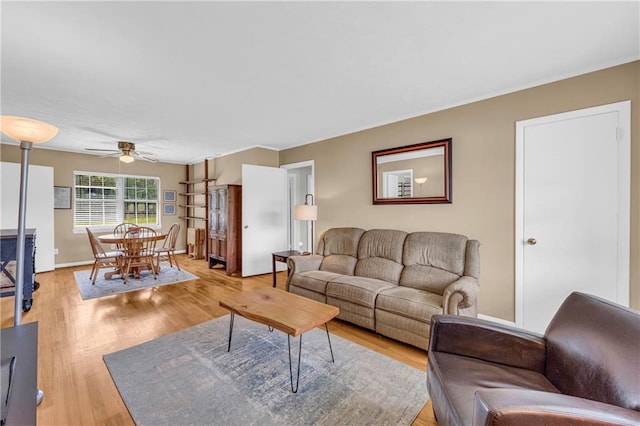 living area with ceiling fan and light wood-style flooring