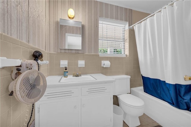 full bath with tile walls, vanity, toilet, and shower / tub combo with curtain