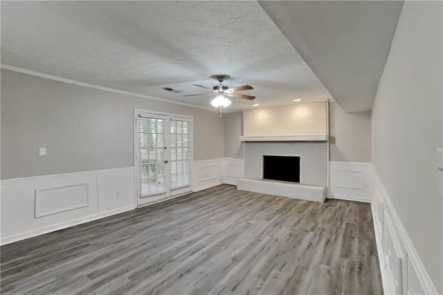 650 Lake Forest Ct, Roswell, GA 30076 - unfurnished living room featuring a decorative wall, a fireplace, a ceiling fan, wood finished floors, and crown molding