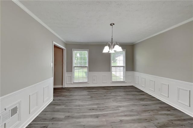 650 Lake Forest Ct, Roswell, GA 30076 - unfurnished dining area featuring a chandelier, wainscoting, wood finished floors, a textured ceiling, and crown molding