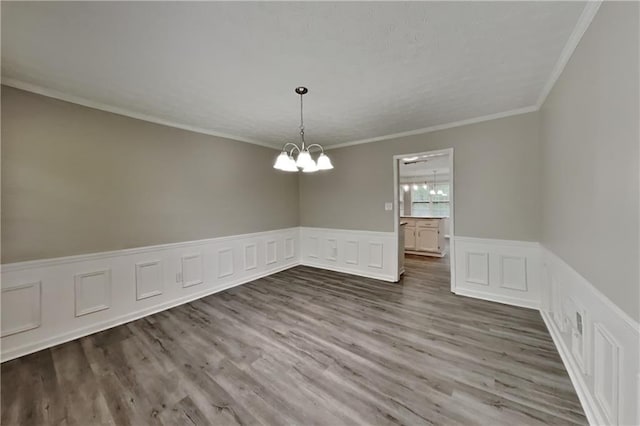 650 Lake Forest Ct, Roswell, GA 30076 - empty room featuring a chandelier, wainscoting, wood finished floors, ornamental molding, and a decorative wall
