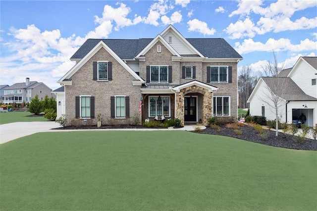 view of front facade featuring a front lawn, brick siding, and roof with shingles