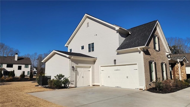 view of home's exterior with central air condition unit, brick siding, concrete driveway, and an attached garage