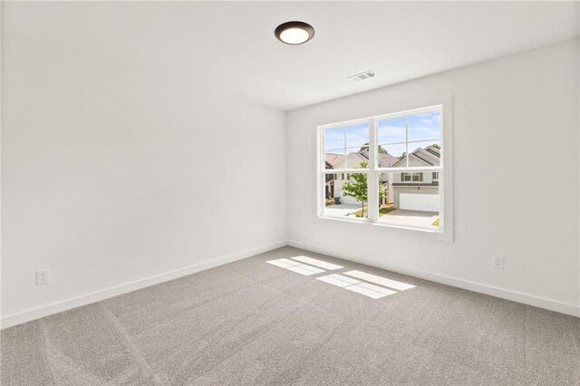 unfurnished room featuring baseboards, visible vents, and carpet flooring