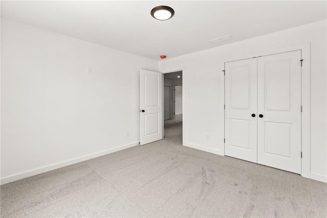 unfurnished bedroom with a closet, carpet, and baseboards