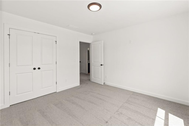 unfurnished bedroom with carpet, baseboards, and a closet