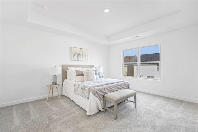 bedroom featuring a raised ceiling, carpet flooring, visible vents, and baseboards