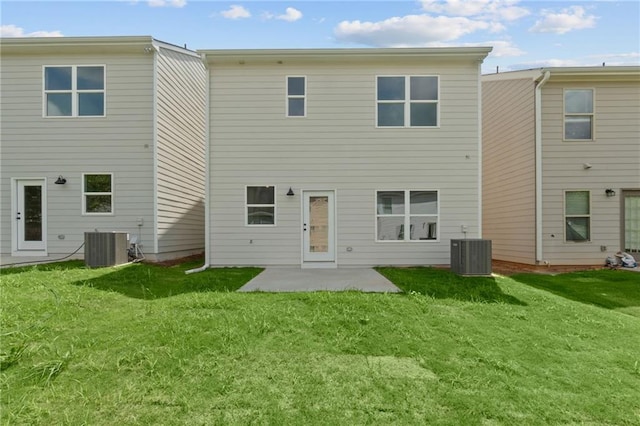 back of house with a patio area, a lawn, and central air condition unit