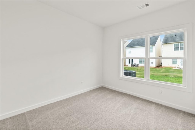 unfurnished room with carpet floors, visible vents, and baseboards